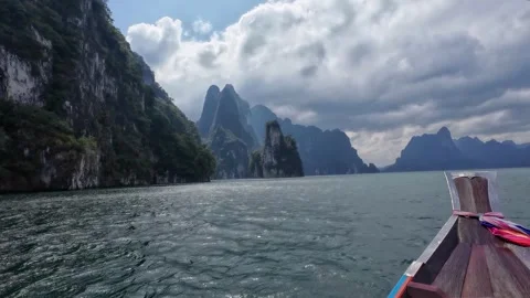 Longtail Boat Passing Limestone Cliffs on Cheow Lan Lake Stock Footage 329072929