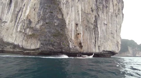 Longtail Boat Rounds the Point of a Towering Seacliff in Thailand Stock Footage 64952994