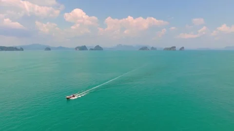 Longtail boat sailing across turquoise ocean near distant islands Stock-Footage 341328682