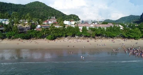 Longtail boats lined along a busy resort beach 库存影片 71297340
