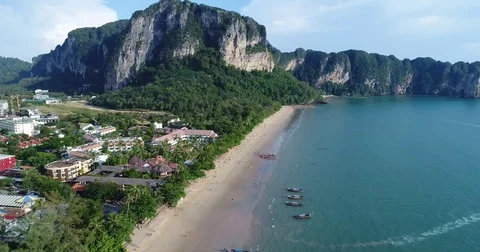 Longtail leaving a crowded beach below limestone crags Vídeos de archivo 71299350