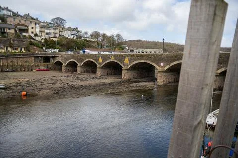 Looe Bridge Over Tidal River in Cornwall with Boats and Hillside Houses 库存照片