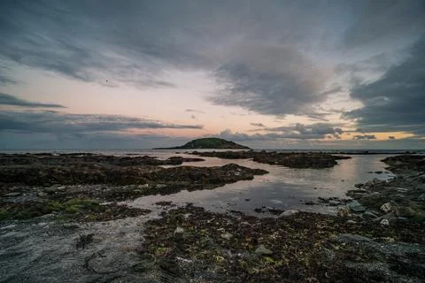 Looe Island dramatic sunset sky over rocky coastline Cornwall Фото