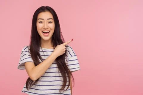 Look at advertisement! Portrait of charming asian girl in striped t-shirt poi Stock Photos