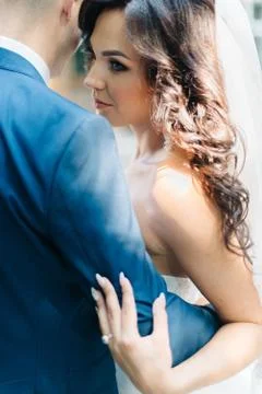 Look from behind at elegant bride hugging her groom in blue Stock Photos