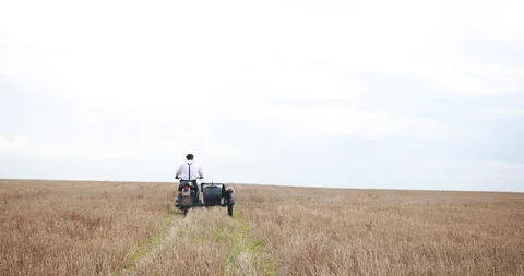 Look from behind at a strong man dressed in old fashioned style and riding on an Stock Footage 96879833