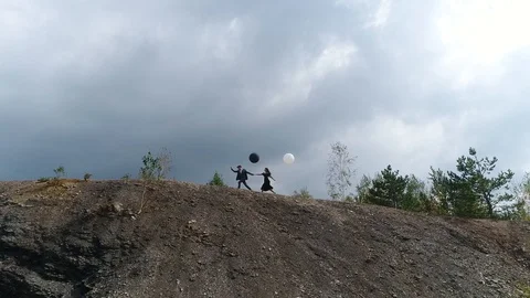 Look from below at a couple dressed in retro clothes an d running with black and Stock Footage 101791705