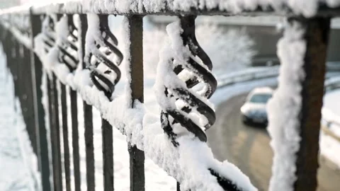 A look from the bridge over the snow covered fence at passing cars on the road Stock Footage 167109730