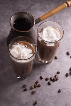 A look down at the coffee maker and two glasses of iced coffee with whipped c Stock Photos