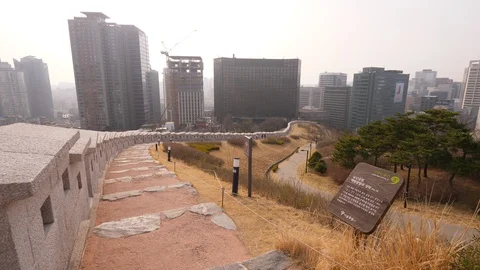 Look down to Namsan trail, reconstructed wall and park, city on background Stock Footage 121647147