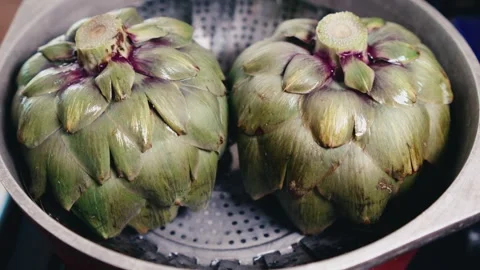 Look down at two artichokes steaming Stock Footage 280331023