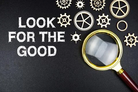 Look For The Good text message with magnifying glass on black background Stock Photos