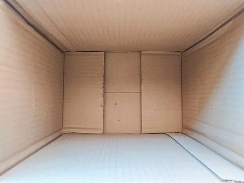 Look inside an empty cardboard box, a stark symbol of transition and new begi Stock Photos