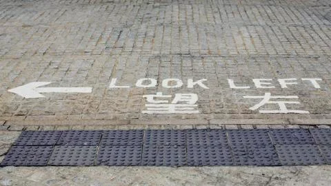 Look left, danger road warning on road. Direction street sign. Stock Photos