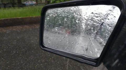 Look at left rear mirror during heavy rain with hailstones in traffic Stock Footage 129994084