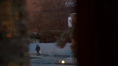 Look out through the window. Passers walk along the empty street in the evening. Stock Footage 108005016