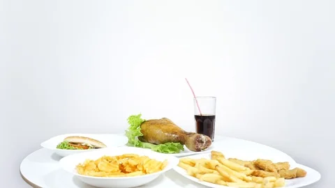 Look out from under the table and steal food.Funny about junk food. Stock Footage 122819694