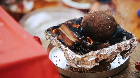 Look over the table at cocounut burning on the bowl Stock Footage 68668725