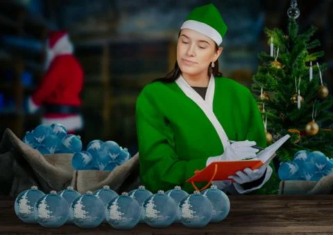 Look into santa's workshop as an elf is checking christmas tree balls Stock Photos