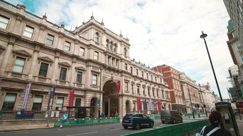 A look in slow-motion of busy traffic in front of the Burlington House. Stock Footage 143302234