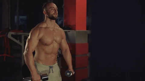Look of strong man doing exercise with dumbbells in studio. 4K Video stock 81577258