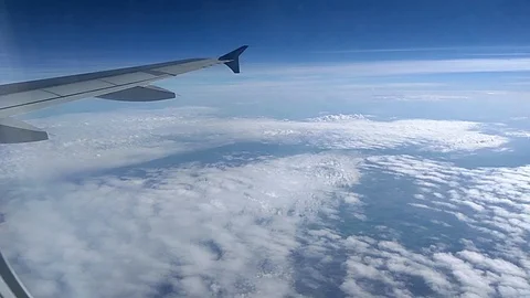 Look through an airplane window - airplane wing in sky Stock Footage 92865989