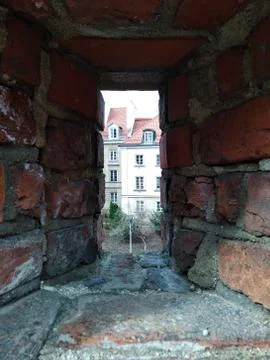 Look through the red brick wall at the modern buildings. historic centre. a m Foto stock