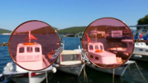 Look through rose-colored glasses at fishing boats swaying at quay in sunny day Stock Footage 166893959