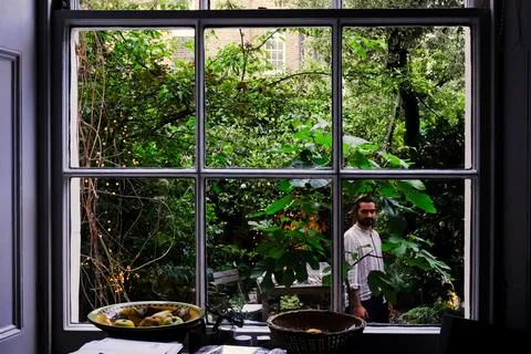 Look through a window of a mid aged man standing outside Stock Photos