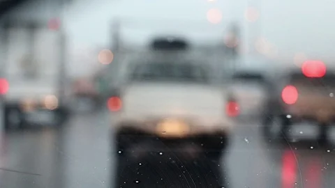 A look through the windshield of a car with working wipers at blurred road. Stock Footage 93778789