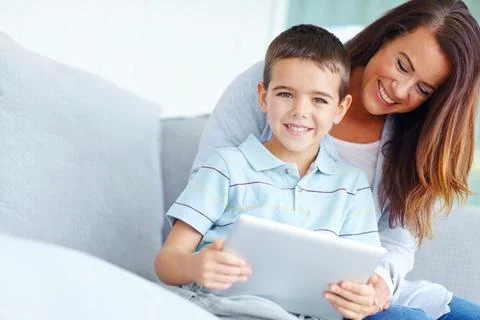 Look at what I can do, mom. A mother helping her son use a digital tablet. Fotos de archivo