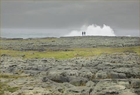 Looking across a limestone pavement at two people Stock Photos