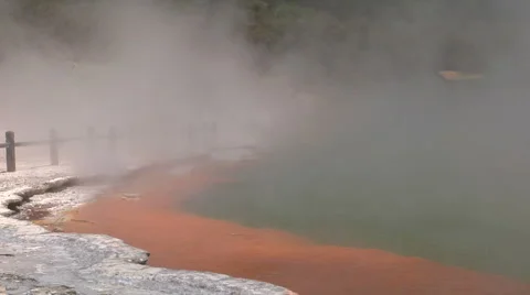 Looking across steaming geothermal pools at tourists Stock Footage 4903875