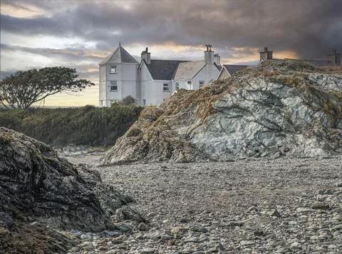 Looking across a stoney beach at a house Stock Photos