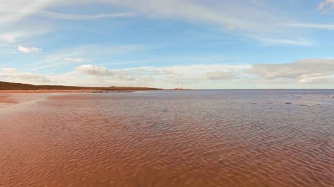 Looking along the beach towards St Mary's lighthouse from Whitley Bay beach Stock Footage 132663286