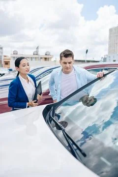 Looking at automobiles in car dealership Stock Photos