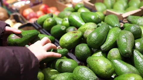 Looking at an avocado in the supermarket Stock Footage 256858773