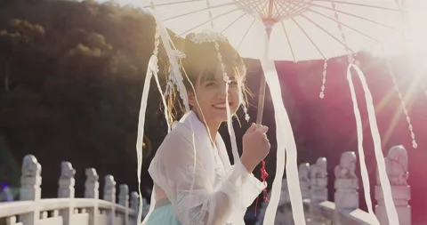 Looking back, authentic beautiful cultural Chinese woman walking with umbrella o Stock Footage 201095718