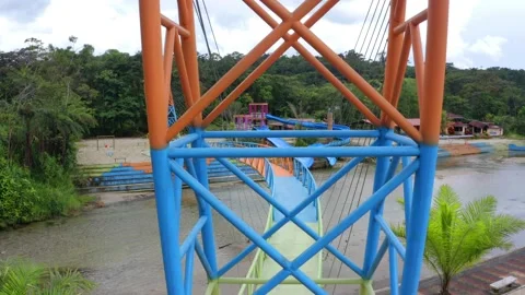 Looking between the colorful metal posts of a steel pedestrian bridge Stock Footage 154694129