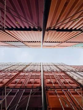 Looking Up Between Container Stacks on Cargo Ship with Open Sky and Geometric Co Stock Photos