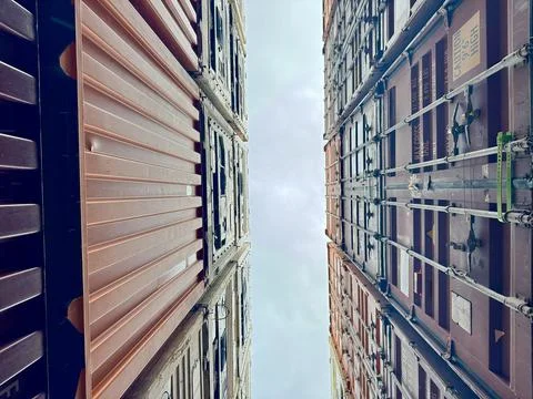 Looking Up Between Stacked Shipping Containers on Container Ship with Symmetrica Stock Photos