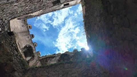 Looking up at the blue sky and sun from inside an ancient castle Vidéo 340896183