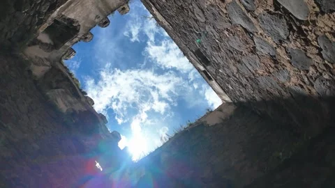 Looking up at the blue sky and sun from inside an ancient castle Stock Footage 341567230