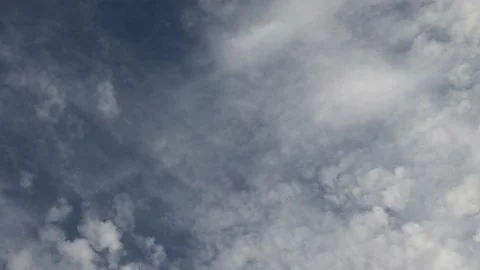 Looking up into a blue sky filled with wispy and puffy  white and grey clouds.   Stock Footage 146385948