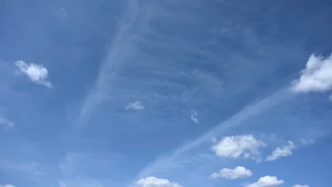 Looking up into a blue sky at white puffy clouds moving in a time lapse. The clo Stock Footage 317731784