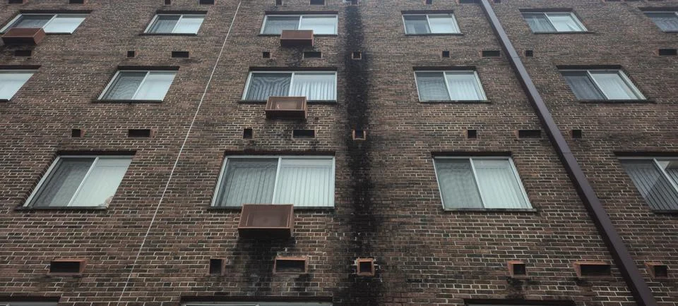 Looking up a brick building with many windows Stock Photos