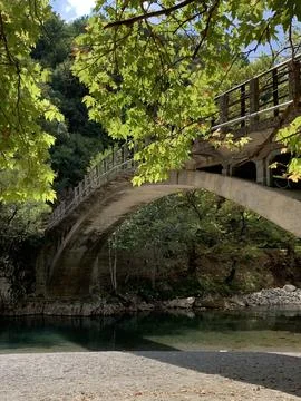 Looking at the bridge over Voidomatis river near Aristi Greece in the summer. Stock Photos