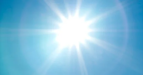 Looking up at bright, vivid sun with sunbeams and lens flare on blue summer sky Stock Footage 113292486