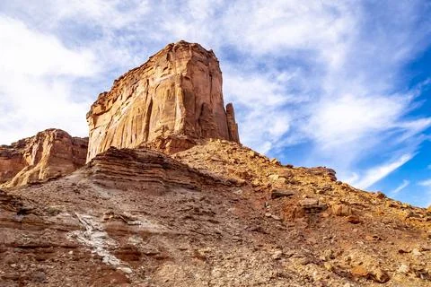 Looking up at a butte with wispy white clouds and a brilliant blue sky Photos