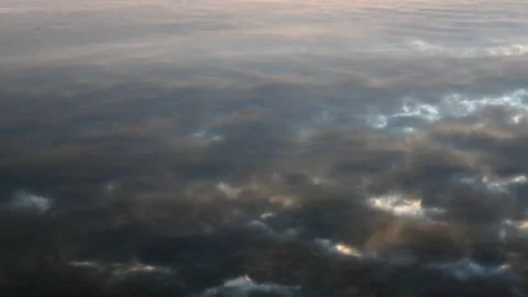 Looking into calm water as very small waves distort the reflection of a cloudy Stock Footage 330363830